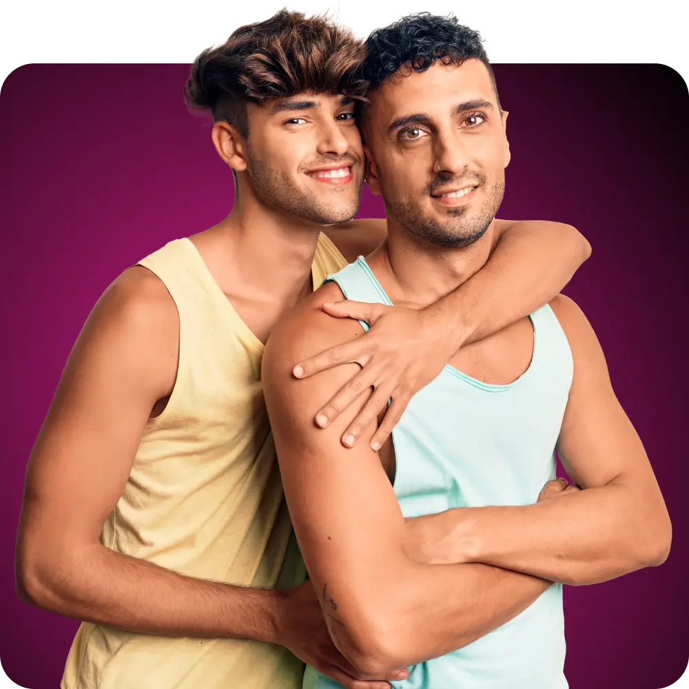 A gay couple in light colored tank tops looking at the camera and smiling